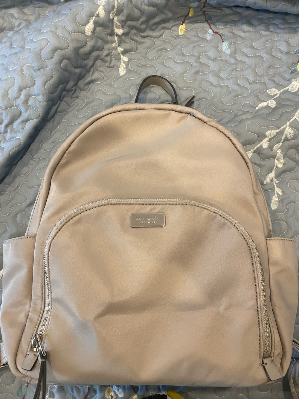 kate spade beige backpack with gold logo plaque